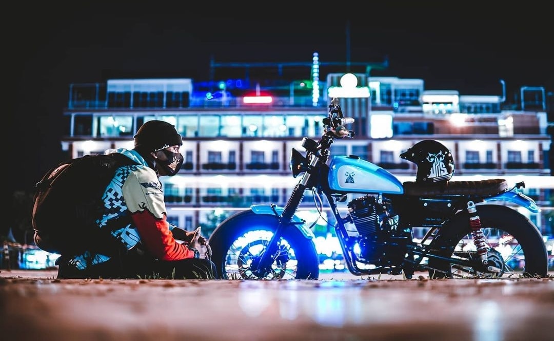 SEORANG biker istirahat sejenak di Dataran Engku Hamidah, dengan latar belakang gemerlap lampu dari sebuah hotel.