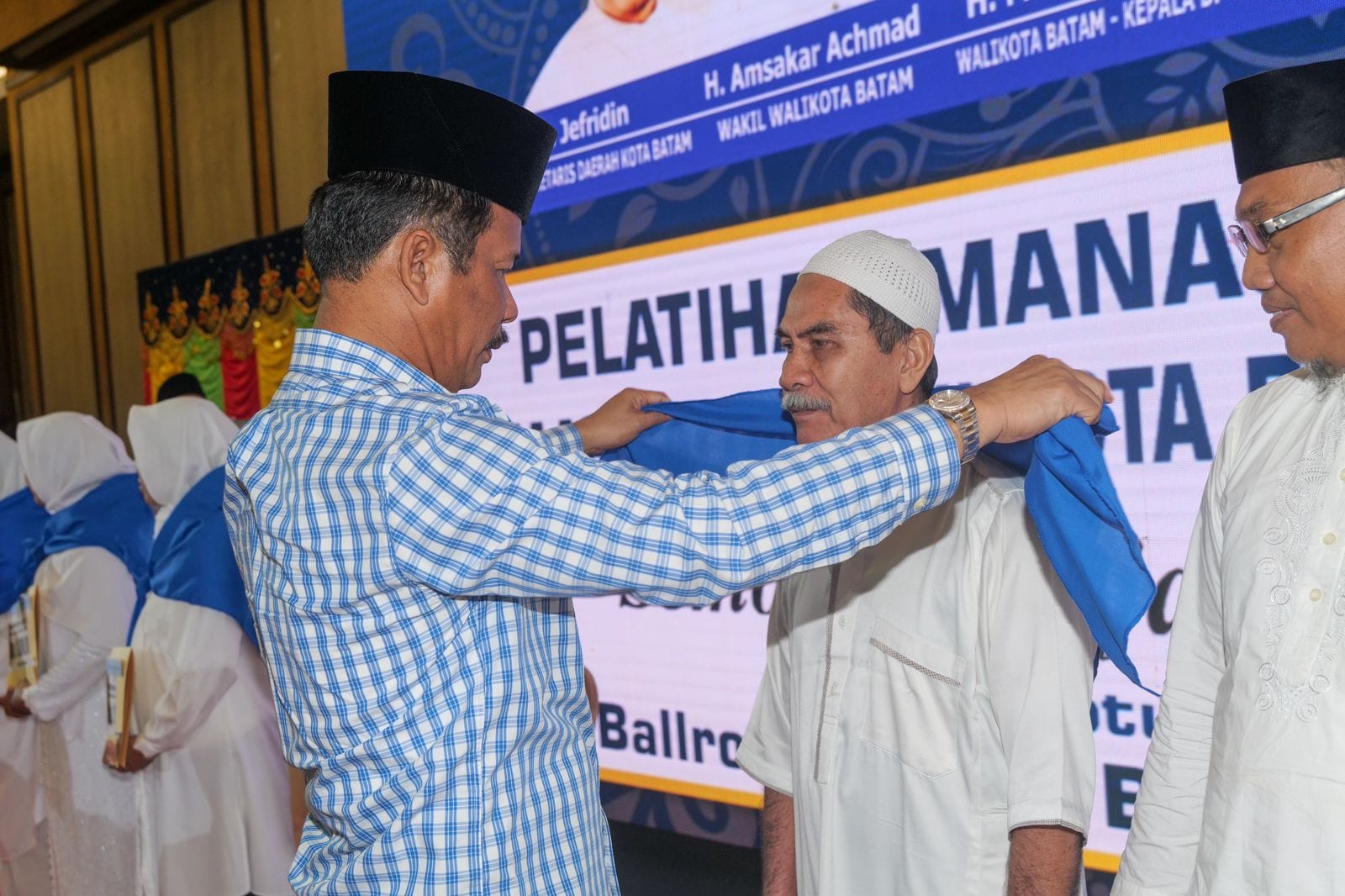 WALI Kota Batam H Muhammad Rudi (HMR), memasang selendang saat melakukan prosesi pelepasan JCH Kota Batam, di Swissbel Hotel Harbour Bay, Sabtu (20/5/2023).