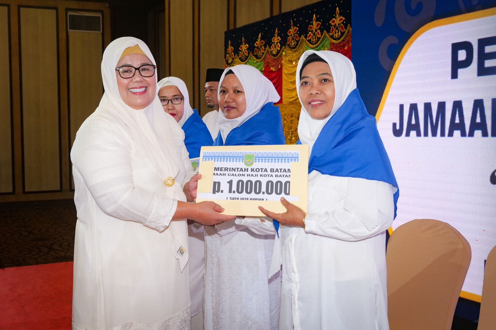 WAGUB Marlin, menyerahkan bantuan saat melepas JCH Kota Batam, di Swissbel Hotel Harbour Bay, Sabtu (20/5/2023).